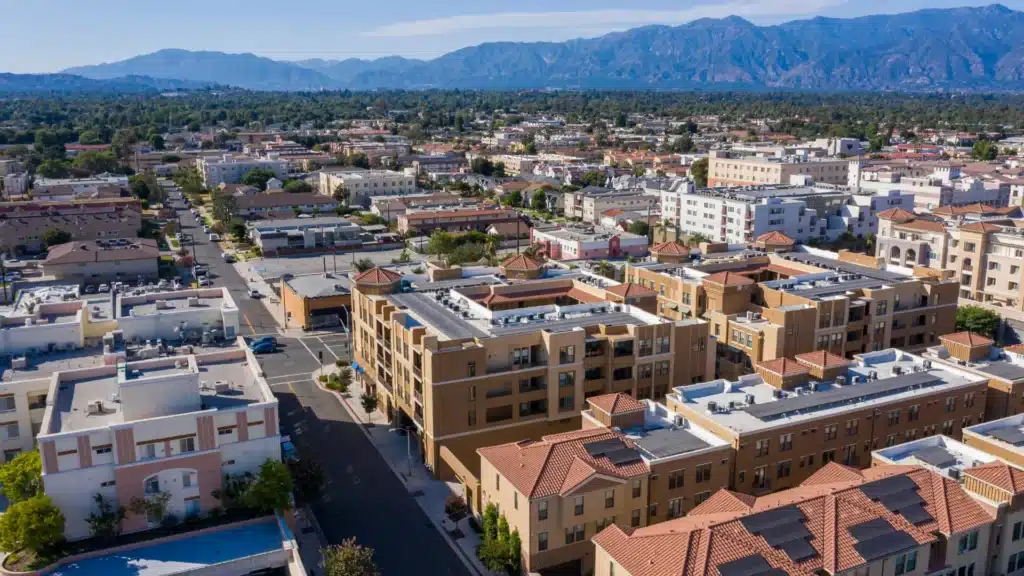 Aerial view of a dense urban neighborhood with mountains in the background.